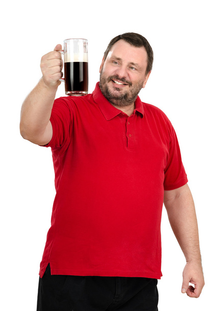 bier drinker staren naar een donker bier tankard - Foto, afbeelding