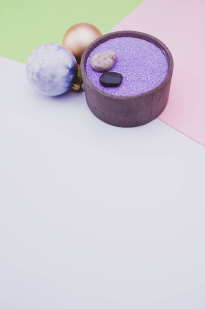 vase with colored sand and Christmas ball decorations on a white background with copy space - Fotó, kép