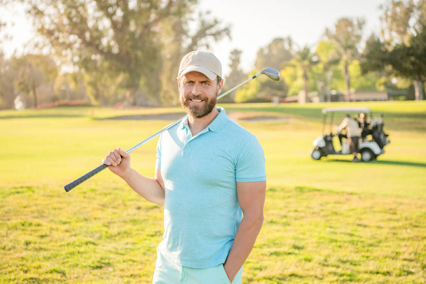 wesoły mężczyzna golfista na profesjonalnym polu z zieloną trawą, sportowiec - Zdjęcie, obraz