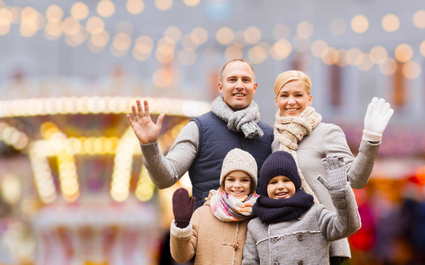 happy family at christmas market or amusement park - Foto, afbeelding
