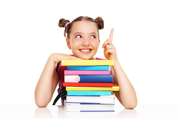 Schoolgirl with books pointing at something  - Zdjęcie, obraz