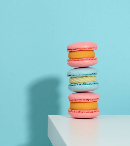 baked pinke round macarons on a blue background, delicious dessert - Photo, Image