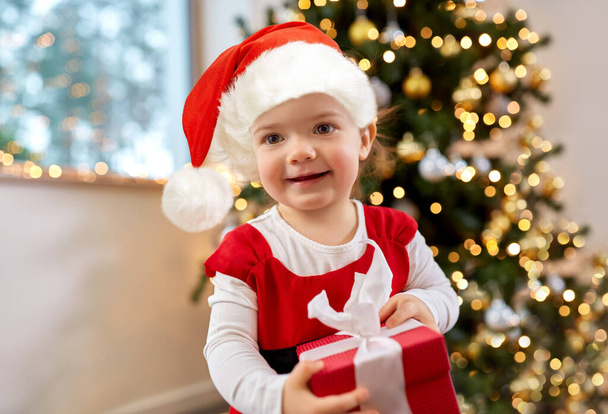 happy baby girl with christmas gift at home - Фото, изображение