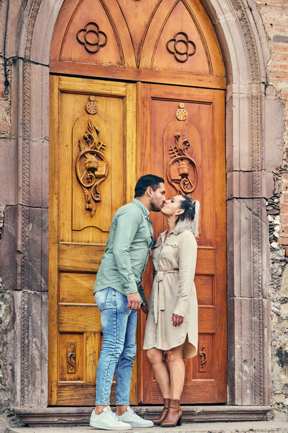 Young Latin male and female couple in love giving each other a kiss between 25 and 35 years old - Fotoğraf, Görsel