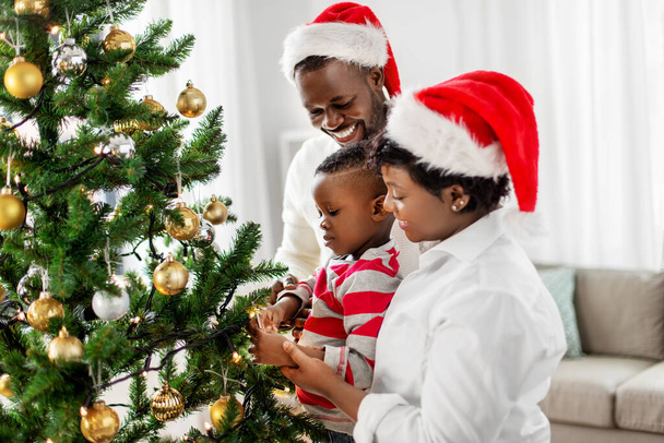 happy family decorating christmas tree at home - Zdjęcie, obraz