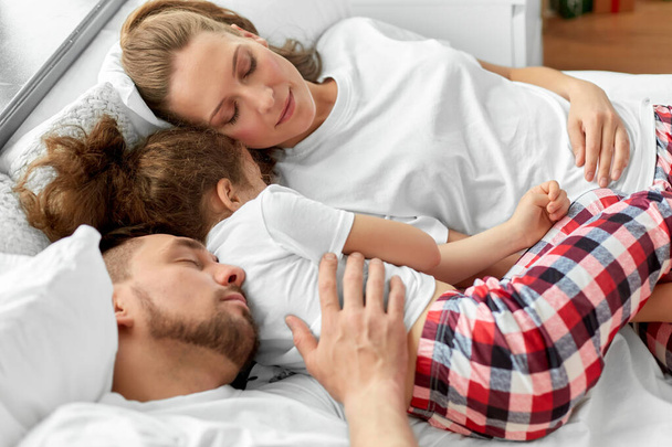 happy family sleeping in bed on christmas morning - Foto, afbeelding