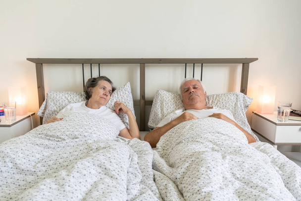 senior aging married couple man male and female woman sleep resting together in bed at home apartment sexual problems dysfunction - Photo, Image