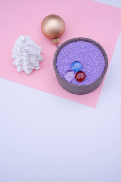 vase with colored sand and Christmas ball decorations on a white background with copy space - Foto, immagini