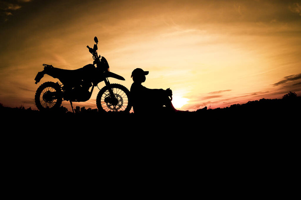 Silhouettes of man traveling on motorbike on sunset background - Photo, Image