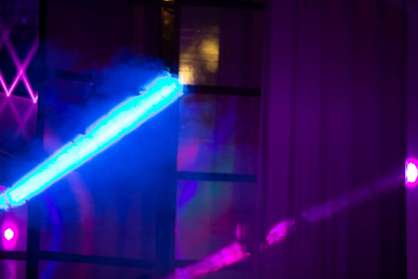 Raios multicoloridos de luz de um holofote de palco em um fundo azul. - Foto, Imagem