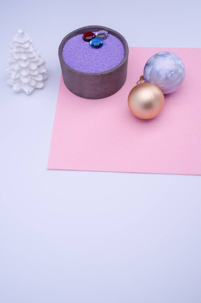 vase with colored sand and Christmas ball decorations on a white background with copy space - Foto, Bild