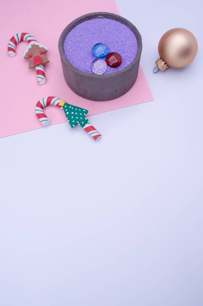 vase with colored sand and Christmas ball decorations on a white background with copy space - Photo, Image