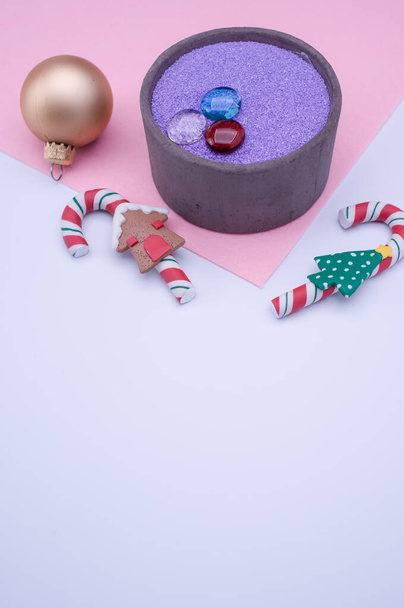 vase with colored sand and Christmas ball decorations on a white background with copy space - 写真・画像