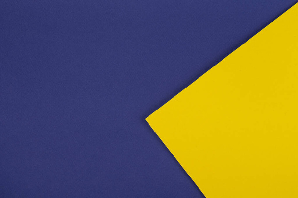 Χαρτί μπλε φόντο με κίτρινο τρίγωνο. Χρωματιστά γεωμετρικά σχήματα χαρτιού με μπλε και κίτρινες αποχρώσεις. - Φωτογραφία, εικόνα