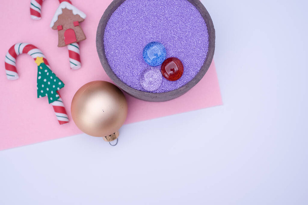 vase with colored sand and Christmas ball decorations on a white background with copy space - Φωτογραφία, εικόνα