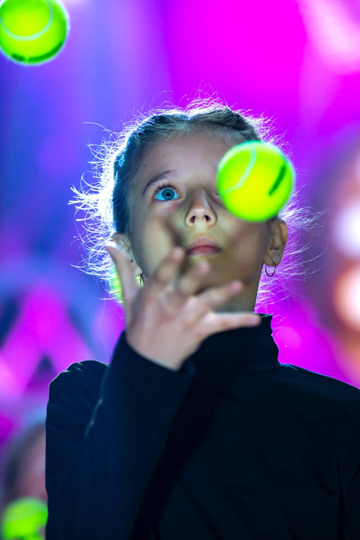 Kleines Mädchen jongliert mit Bällen. Die Zirkuskunst des Jonglierens. - Foto, Bild