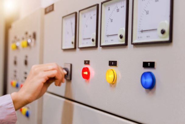 Inženýrem je kontrola napětí nebo proudu voltmetrem v ovládacím panelu elektrárny a kontrola systému připravena . - Fotografie, Obrázek