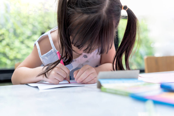 Images floues d'une fille asiatique de 3 ans se concentrent faire de l'art en utilisant des crayons de couleur, concept pour les enfants et l'éducation en ligne. - Photo, image