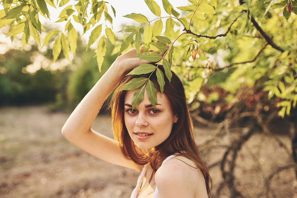 rothaarige Frau in der Nähe von Bäumen grüne Blätter Charme des Sommers - Foto, Bild