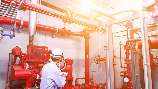 Ingénieur vérifier la pompe de générateur rouge pour la tuyauterie d'arrosage d'eau et le système de contrôle d'alarme incendie. - Photo, image