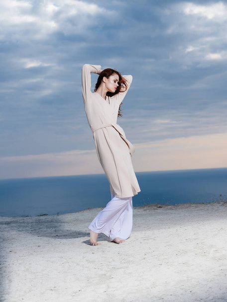 vrouw in jas glamour poseren oceaan zomer landschap - Foto, afbeelding