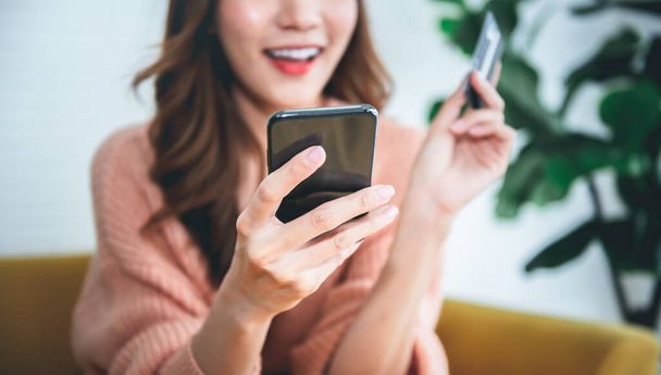 Zamazane miękkie obrazy Azjatki atrakcyjnej kobiety korzystającej z telefonów komórkowych do zakupów online ze szczęściem, do ludzi biznesu i zakupy koncepcji online. - Zdjęcie, obraz