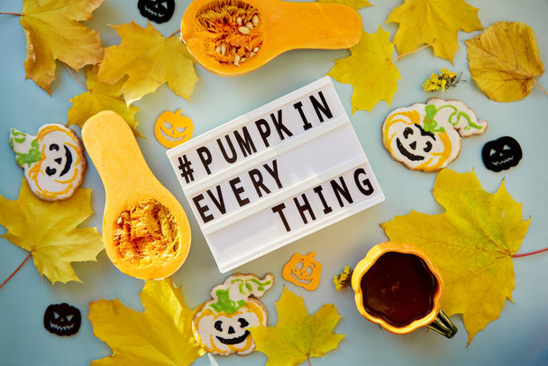 Text pumpkin everything among autumn decorations and food. Orange teacup with homemade cookies, fresh pumpkins, yellow leaves and decorations of pumpkins. High quality photo - Photo, Image