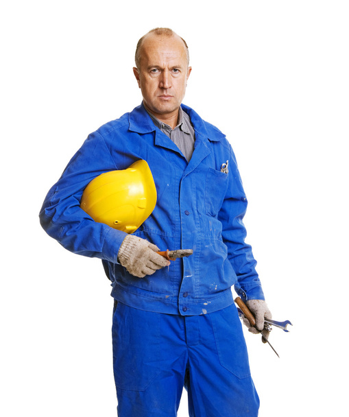 Trabajador serio sosteniendo su hardhat y diferentes herramientas
 - Foto, imagen