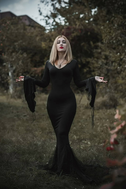 Bruxa em vestido preto, conceito de Halloween, ideias para a festa, senhora perfeita em roupas góticas escuras - Foto, Imagem
