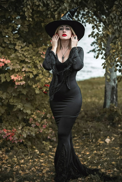 Czarownica w czarnej sukience, koncepcja Halloween, pomysły na imprezę, idealna pani w ciemnogotyckich ubraniach - Zdjęcie, obraz