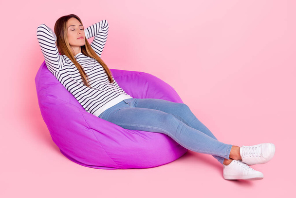 Photo of dreamy sweet mature lady wear striped sweater smiling sitting beanbag arms behind head closed eyes isolated pink color background - Valokuva, kuva
