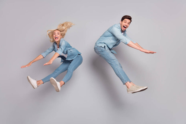Full length body size view of attractive friends friendship jumping having fun fooling isolated over grey pastel color background - Photo, image