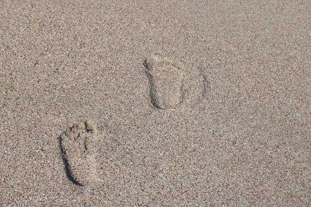 Lábnyomok a homokban a strandon nyáron - Fotó, kép