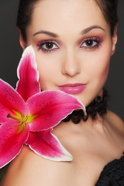 ピンクの花を持つ魅力的な女性 - 写真・画像