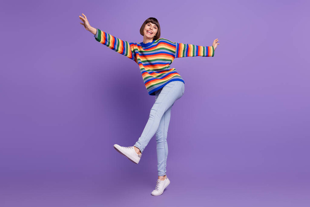 Photo of crazy funny carefree lady enjoy dance wear striped sweater jeans shoes isolated violet color background - Fotó, kép