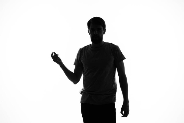 Человек жестикулирует руками в тени, позируя студией инкогнито - Фото, изображение