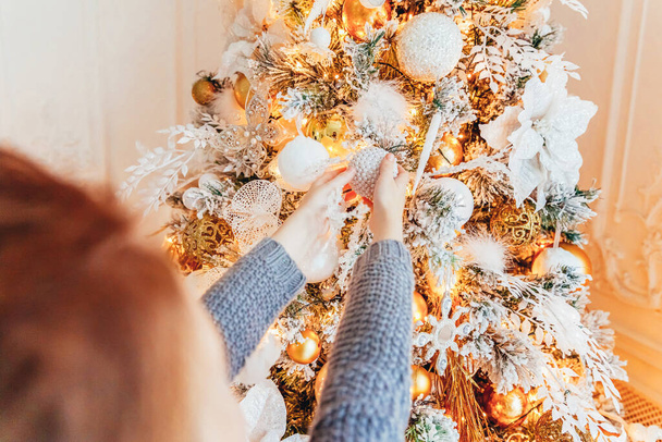 Little girl decorating Christmas tree on Christmas eve at home. Young kid in light bedroom with winter decoration. Happy family at home. Christmas New Year december time for celebration concept - Foto, Bild
