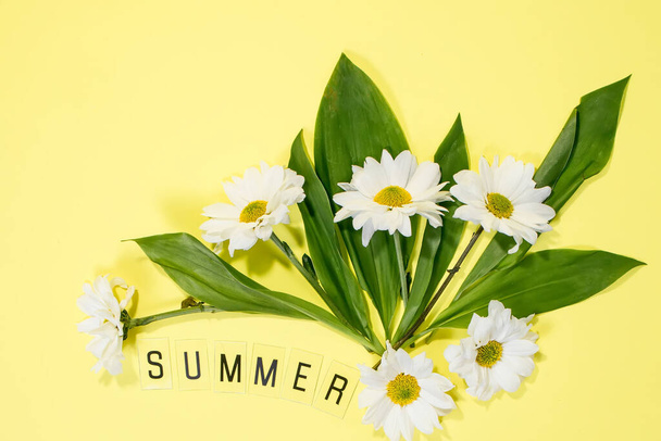 Text SUMMER from letters and field chamomiles flowers on yellow background. Greeting card Flat Lay Copy space Concept Hello summer, summertime. - Zdjęcie, obraz