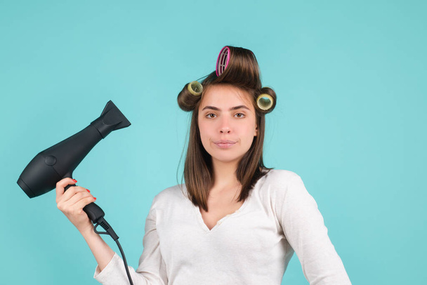 Woman with hair dryer. Beautiful girl with straight hair drying hair with professional hairdryer Woman with hair dryer isolated in studio. Beautiful girl with straight hair drying hair with - 写真・画像