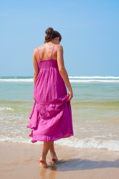 Atractiva mujer caminando hacia el océano
 - Foto, imagen