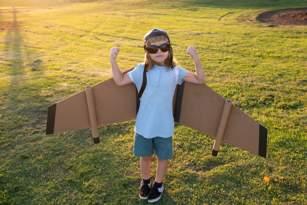 Power superhero child shows muscles. Boy dreams of flying. Carefree child playing outdoors. Travel and summer vacation concept. - Photo, image