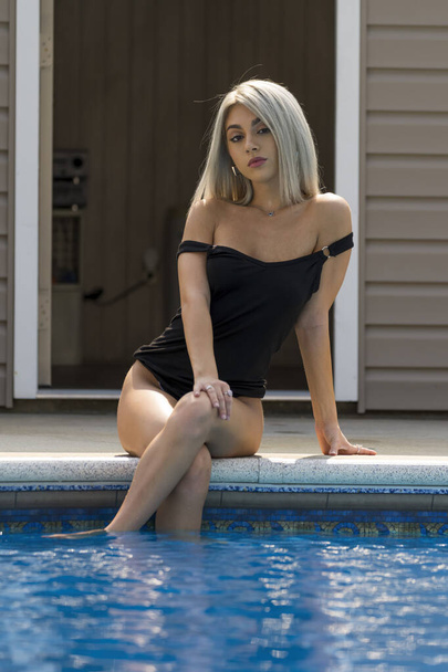 Un magnifique modèle de bikini blond profite d'une journée à la piscine un jour d'été - Photo, image