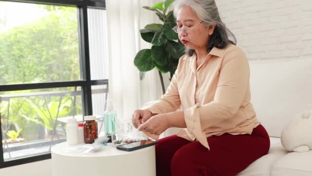 Ältere Frau nimmt Paracetamol-Tabletten gegen Kopfschmerzen. Schmerzen durch Grippe, Zahnschmerzen, Muskelkrämpfe am Morgen nach den Mahlzeiten. - Filmmaterial, Video
