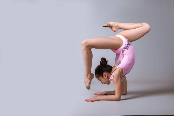 The gymnast girl performs an element in the shape of a square. - Foto, imagen