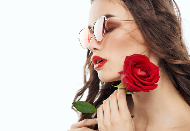 ελκυστική γυναίκα και κόκκινα χείλη τριαντάφυλλο λουλούδι close-up μπλε φόντο - Φωτογραφία, εικόνα