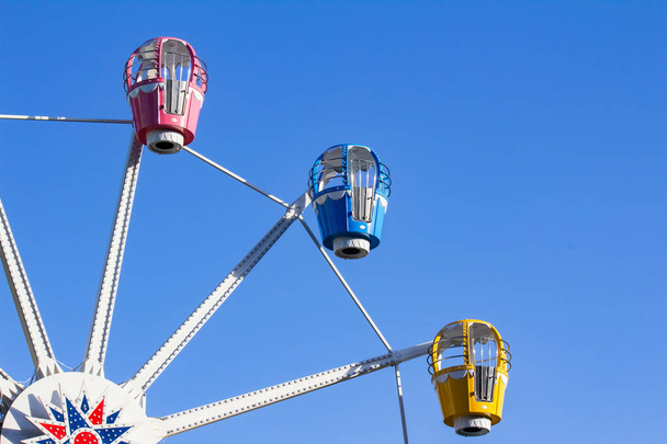 Photo of ferris wheel booths on blue sky background. - Photo, Image