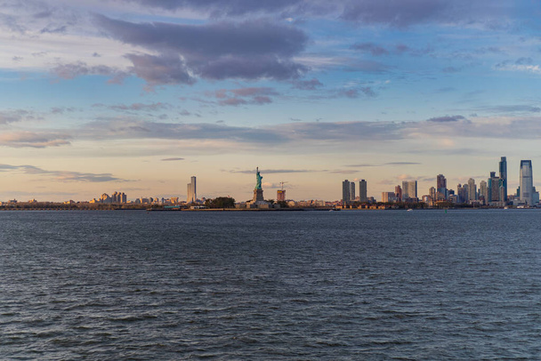 View of the Statue of Liberty from the water at sunset, New York - Fotó, kép