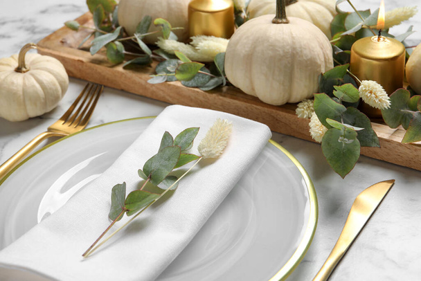 Festive table setting with autumn decor on white marble background, closeup - Foto, afbeelding