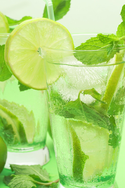 Two mojito cocktails on green background - Foto, afbeelding