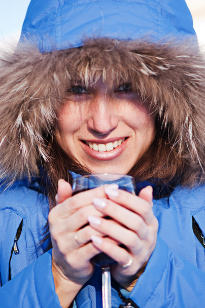 vrouw in blauwe jas met glas wijn - Foto, afbeelding